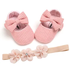 Zapatos de bebé de punto rosa con lazo grande y diadema de flores a juego
