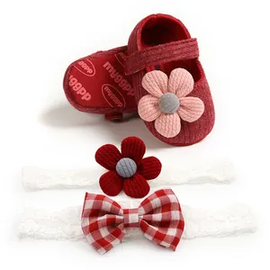 Detailed view of red knitted baby shoes and matching lace floral headbands set