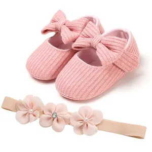 Vista detallada de los zapatos de princesa de punto rosa y la diadema de flores
