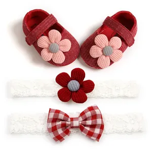 Close-up detail of red knitted baby shoes and lace headbands with flower and bow accents