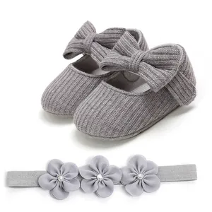 Zapatos de bebé de punto gris con lazo y diadema floral a juego set vista de detalle.