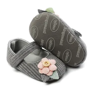 Close-up of grey knit baby princess shoes featuring pink flower and non-slip sole