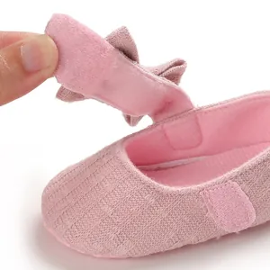 Macro detail showing the soft Velcro strap closure on a pink fabric baby walking shoe