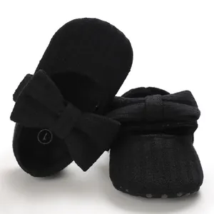 Close-up of black baby princess shoes with soft soles and large bow details