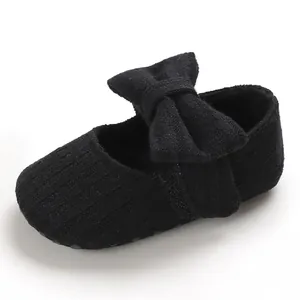 Close-up of black knitted baby princess shoe featuring a large bow and soft non-slip sole
