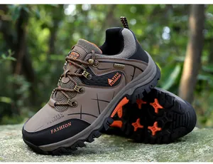Men's brown hiking shoes with orange non-slip sole shown in an outdoor forest
