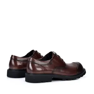 Zijaanzicht van donkerbruine leren nette schoenen met dikke profielzolen en vintage.