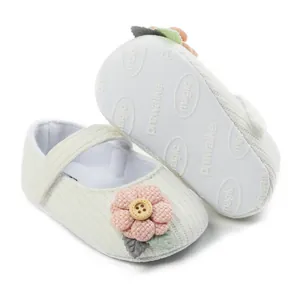Soft white knitted baby prewalker shoes with pink flower and wooden button detail
