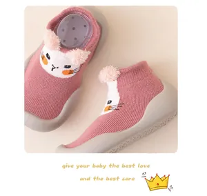 Dettaglio di scarpe da passeggio per neonati con gatto rosa, suola morbida e pompon