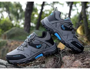 Detailed side view of men's grey and black outdoor hiking shoes with thick non-slip soles.