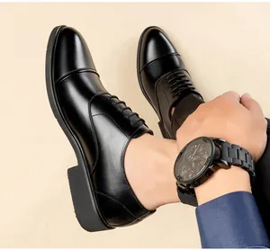 Gros plan sur des chaussures de ville noires en cuir à talons compensés cachés