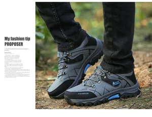 Detailed macro view of men's outdoor hiking shoes with thick non-slip blue rubber soles.