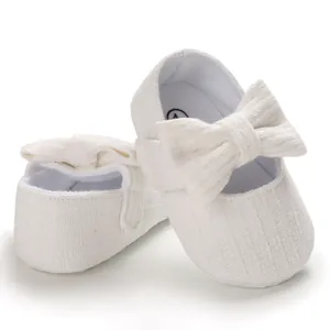 Detailed view of white soft-sole baby princess shoes with ribbed fabric and bow decoration