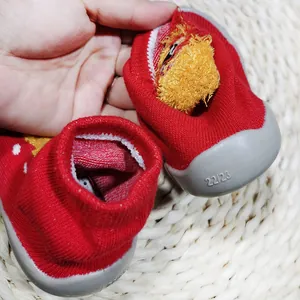 Dettaglio dell'interno e della taglia 22/23 delle scarpe primi passi in maglia rossa