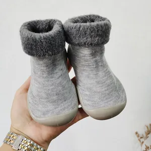 Detalle de patucos de invierno para bebé en gris con forro de pelo sintético y suela blanda.
