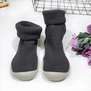 Detalle de los zapatos de calcetín de punto gris para bebé con forro de vellón grueso