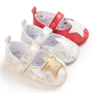 Detalle de tres zapatos de bebé brillantes con un lindo diseño de estrella sonriente