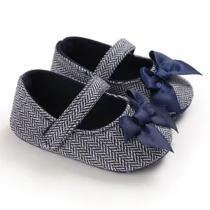 Detailansicht der dunkelblauen Babyschuhe mit Fischgrätenmuster und Satinschleife.