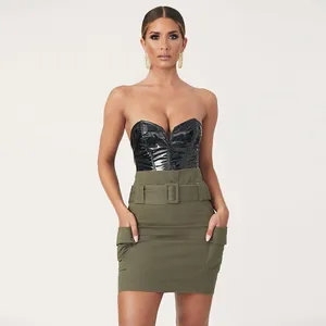 Mannequin portant un body sexy en similicuir noir et une minijupe cargo vert olive.