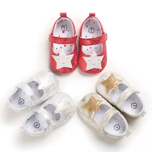 Detalle de zapatos de primeros pasos para bebé niña con purpurina y diseño de estrella