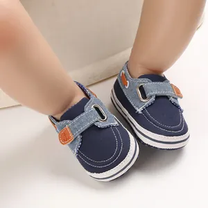 Vista dettagliata di scarpine da neonato blu navy con suole morbide indossate da un bebè.