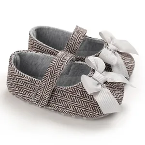 Detailansicht von Baby-Lauflernschuhen mit Fischgrätenmuster und süßer Schleife