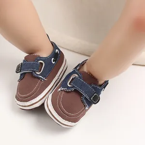 Primo piano di scarpe da camminata per neonati marroni e denim per bimbi da 0 a 1 anno.