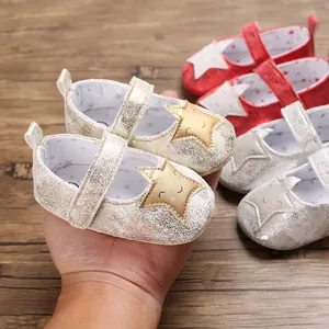 Primer plano de zapatos para bebé con una estrella sonriente dorada y acabado brillante