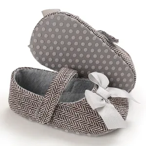 Nahaufnahme von Baby-Prinzessinnenschuhen mit Fischgrätmuster und weicher, rutschfester Sohle