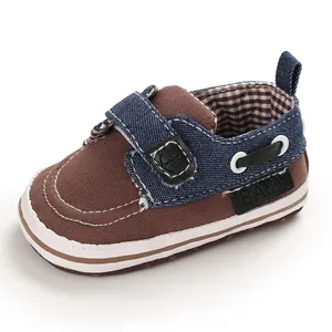 Vista dettagliata di scarpe in tela marrone per neonati con dettagli in denim blu