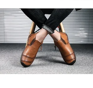 Detail van bruine casual herenlaarzen van leer met rits aan de zijkant en handstiksels.