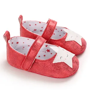 Vista detallada de zapatos rojos de bebé con parches de estrellas y suelas blandas.