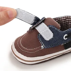 Dettaglio ravvicinato di una scarpa per neonato marrone e blu con cinturino a strappo