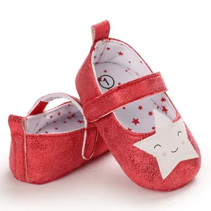 Primer plano de zapatos rojos de purpurina para bebé con un lindo parche de estrella sonriente.