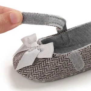 Detailansicht des Klettverschlusses an grauen Baby-Prinzessinnenschuhen mit Fischgrätmuster