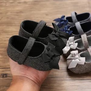 Detailansicht von Baby-Lauflernschuhen mit Fischgrätmuster und Schleifendekoration