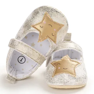 Primer plano de zapatos bebé brillantes champán con lindo parche estrella alegre