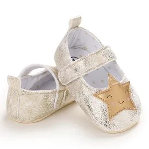 Detalle de zapatos dorados para bebé niña con estrella sonriente y suela blanda para gatear