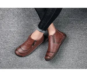 Gedetailleerd overzicht van stijlvolle bruine herenleren hoge schoenen op grijze vloer