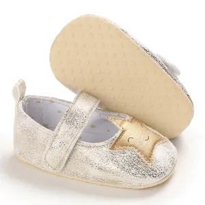 Detalle de la suela antideslizante y la estrella en zapatos dorados para bebés niñas