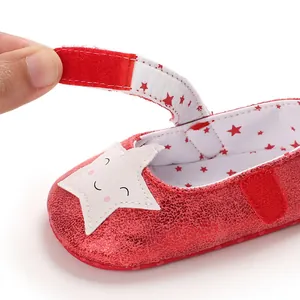 Detalle de zapato de bebé rojo brillante con cierre de velcro y estrella
