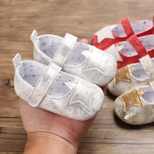 Primer plano de lindos zapatos plateados para bebé con parche de estrella sonriente.