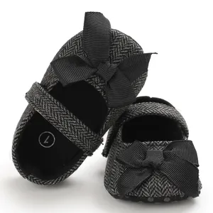 Detaillierte Ansicht von Baby-Lauflernschuhen mit Fischgrätenmuster und schwarzer Schleife