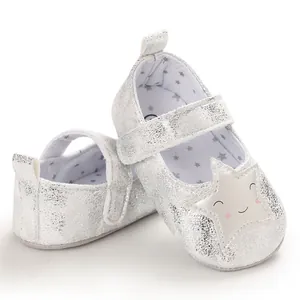 Vista detallada de zapatos plateados para bebé con una estrella sonriente