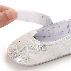 Primer plano de zapato de bebé con estrella plateada y cierre de velcro ajustable