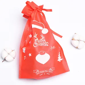 Close-up of red non-woven Christmas drawstring gift bag with white festive prints