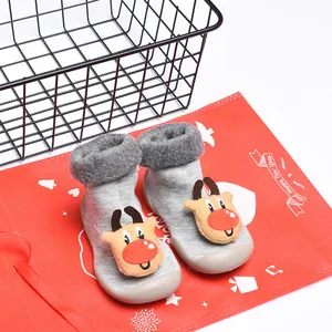Detalle de zapatos de gateo para bebé con forro de felpa y diseño de reno de dibujos