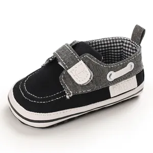 Dettaglio scarpa primi passi per neonati in tela bianca e nera con chiusura a velcro