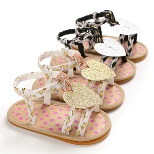 Detail view of baby girl summer sandals with braided straps and glitter heart accents