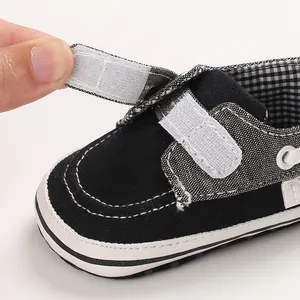 Dettaglio della chiusura a strappo regolabile su una scarpa da passeggio nera per neonati